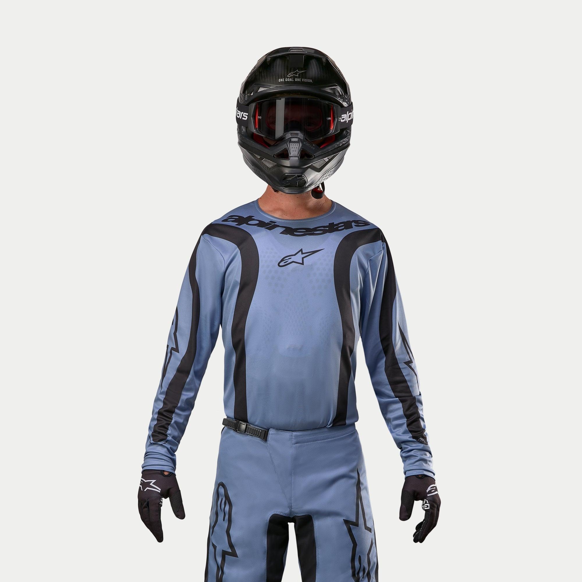 Alpinestars 2024 Fluid Lurv Jersey, motocross-trøje, lyseblå og sort, båret af en rytter med matchende bukser, sort hjelm med røde goggles og sorte handsker, koordineret outfit til off-road racing