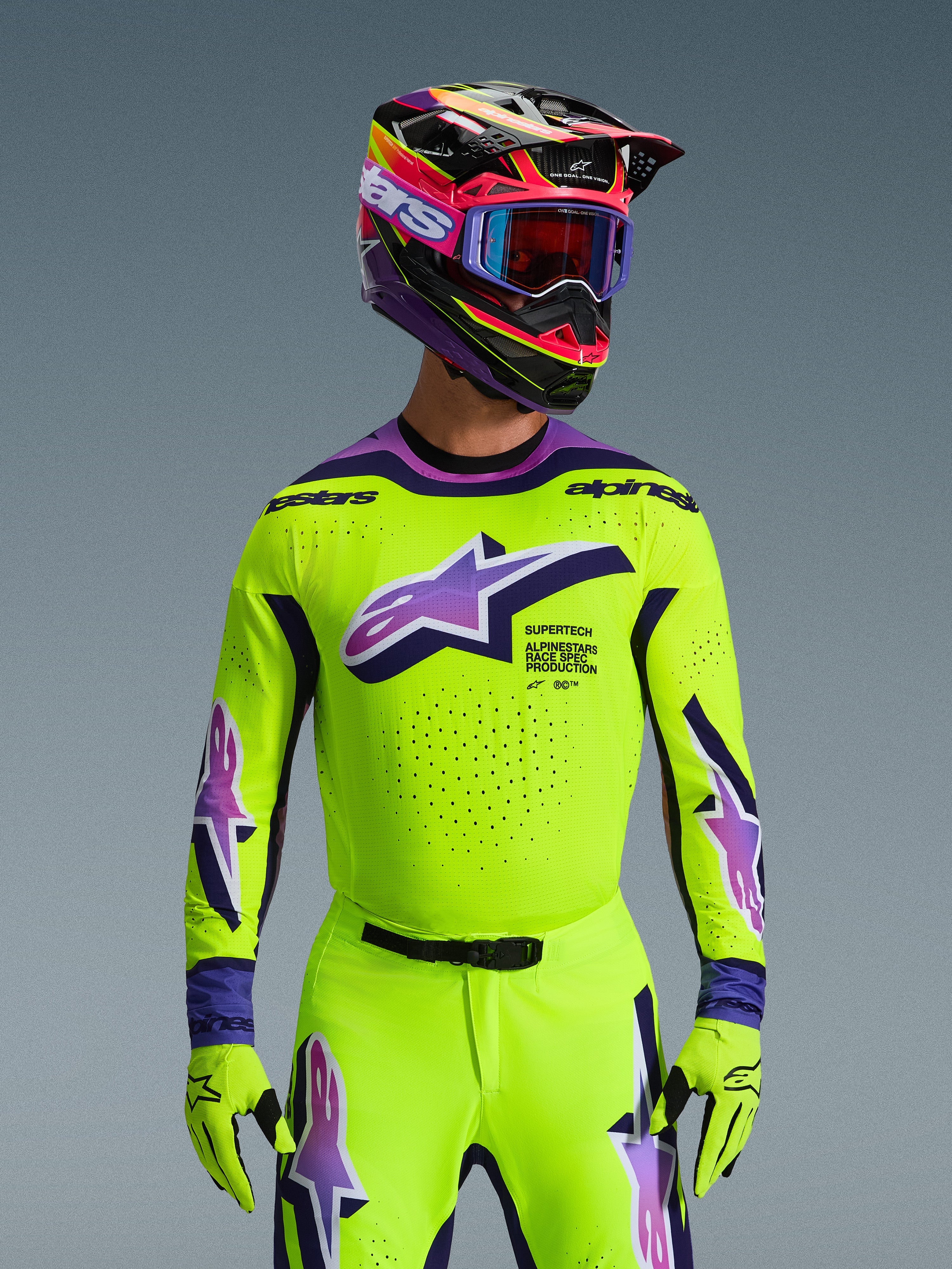 Alpinestars 2026 Supertech Vista udstyrssæt, motocross-kører iført neon-gul trøje og bukser med lilla og blå detaljer, stort Alpinestars-logo på brystet, matchende farverig hjelm og goggles, professionelt raceroutfit