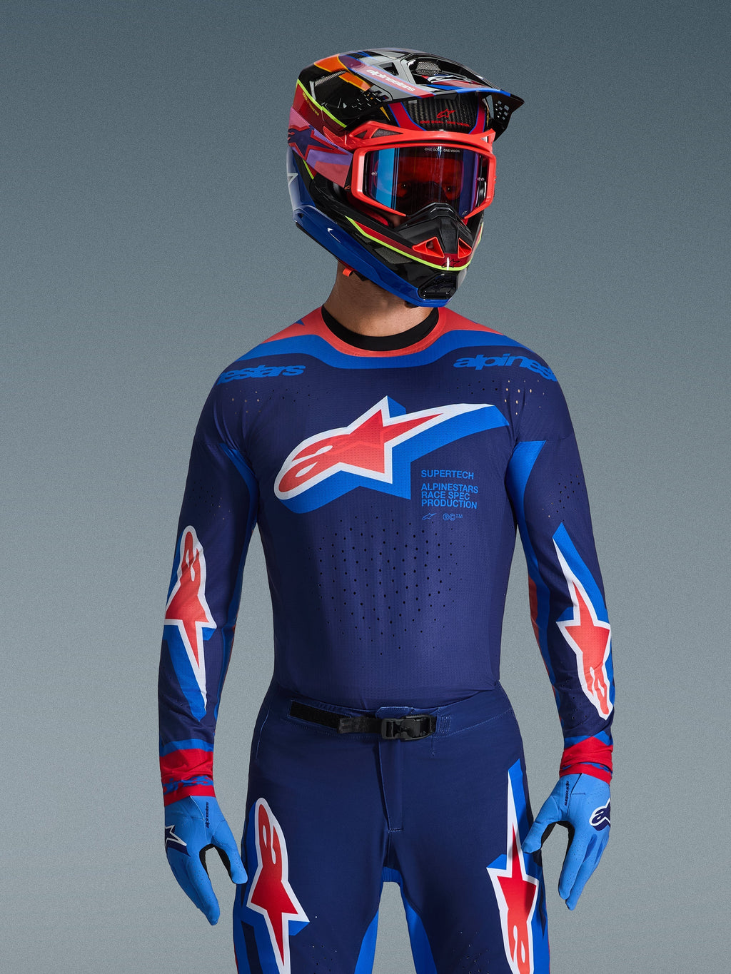 Alpinestars 2026 Supertech Vista jersey, motocross-jersey, mørkeblå, Hot Coral og koboltblå, båret med matchende motocross-bukser og hjelm, med stort stjernelogo på brystet og race spec-branding, atletisk pasform med ventilerede mesh-paneler til elite racing-præstation