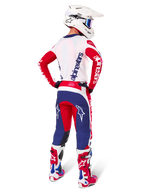 Motocrosskører set bagfra iført Alpinestars Limited Edition Techstar Fortitude Jersey, klar rød, hvid og blå farvekombination, matchende tekniske bukser med stjernelogoer, hvid hjelm med goggles og røde og hvide støvler, komplet koordineret udstyr til off-road racing