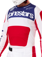 Alpinestars Limited Edition Techstar Fortitude udstyrssæt, motocross jersey og bukser i rød, hvid og blå, hvid jersey med mørkeblåt øvre panel og stor rød grafik, matchende hvide og røde bukser med SX2-magnetspænde, atletisk pasform med laserskårne perforeringer til off-road racing.