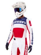 Motocross-rytter iført Alpinestars Limited Edition Techstar Fortitude jersey, rød, hvid og blå, med hvid hjelm, blå goggles og matchende bukser, højtydende racertøj til off-road konkurrence