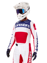 Motocross-rytter iført Alpinestars Limited Edition Techstar Fortitude jersey, rød, hvid og blå, med hvid hjelm, blå goggles og matchende bukser, højtydende racertøj til off-road konkurrence