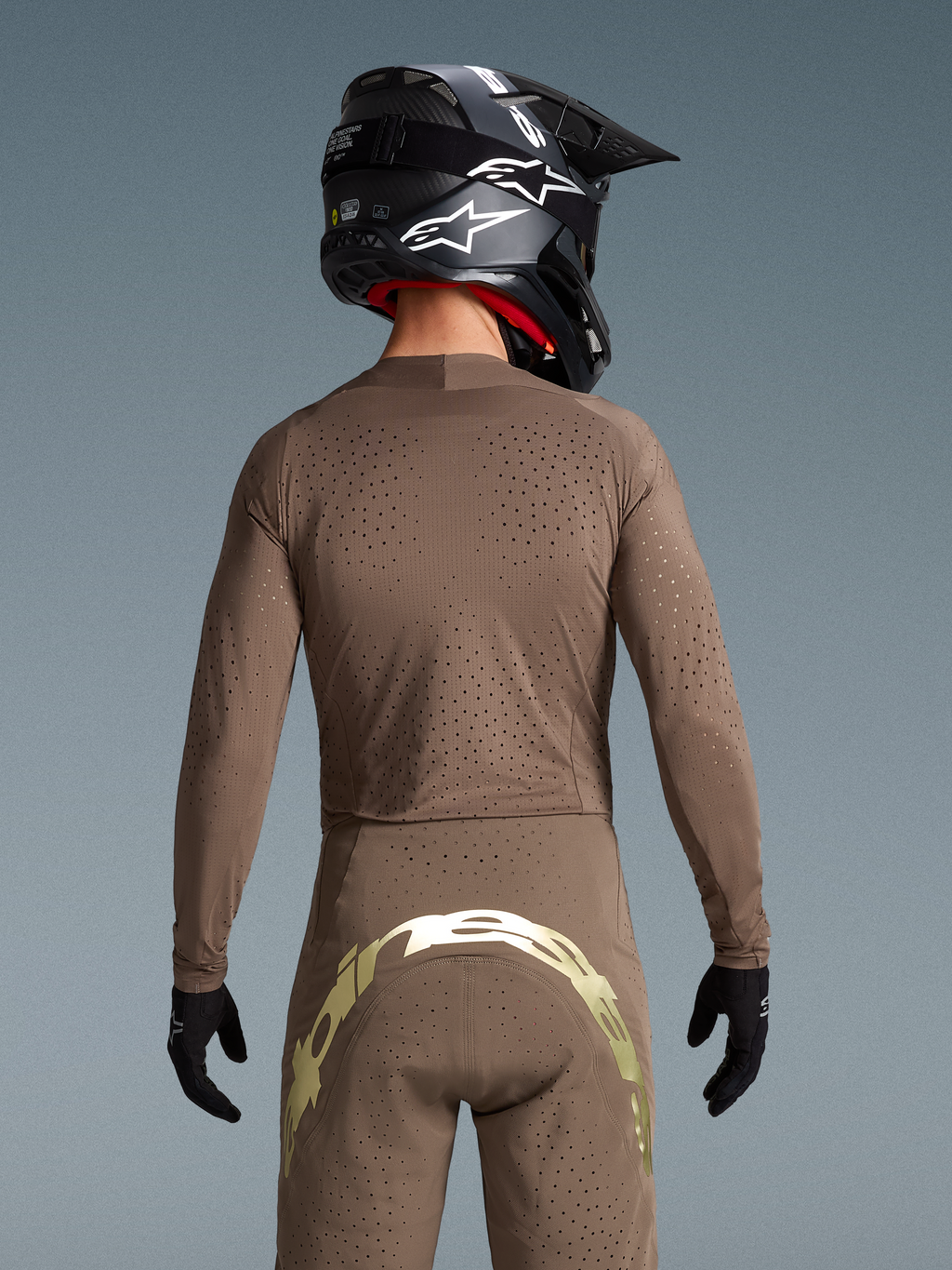 Alpinestars Begrænset Udgave Supertech Air Gold Trøje, brun og guld MX-trøje med laser-skåret ventilation, set bagfra.