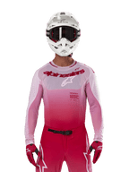 Motocrossrytter iført Alpinestars 2024 Supertech Dade Jersey i Red Berry Lilac, matchende bukser, hvid hjelm med sorte briller og røde handsker, koordineret professionelt raceroutfit med graduerede pink og røde nuancer