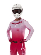 Alpinestars 2024 Supertech Dade-trøje, motocross-racingudstyr, Red Berry Lilac gradient-design, langærmet trøje med laserskårne perforeringer, båret af en kører med hvid hjelm og matchende røde handsker og bukser, professionelt motocross-sæt på hvid baggrund