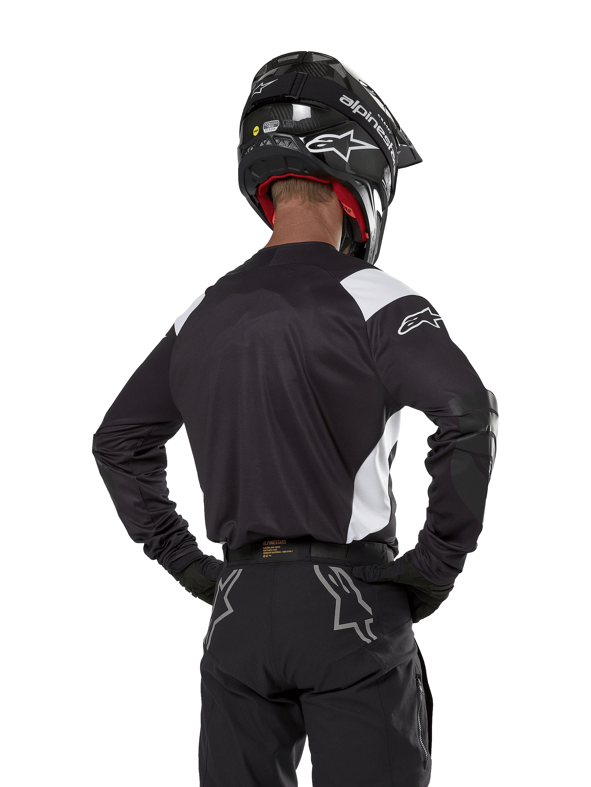 Alpinestars Techdura Jersey, Black with white shoulder accents, back view of motocross rider wearing matching black pants and helmet, reinforced elbow patches, enduro and off-road racing gear
