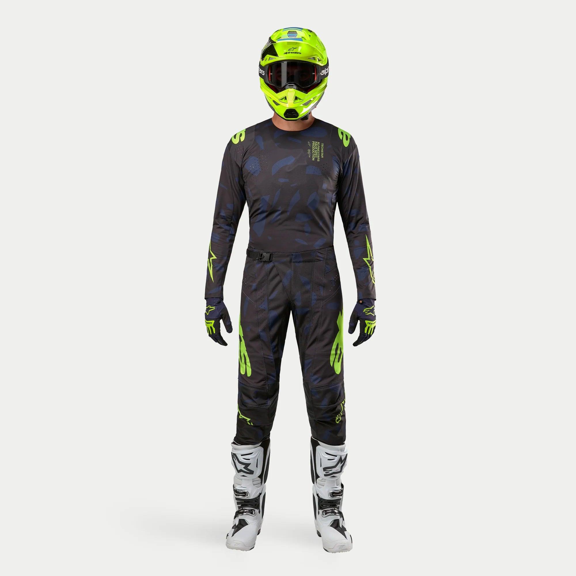 Alpinestars motocross-rytter iført komplet racerudstyr, 2024 Techstar Rantera trøje i Black Navy og Yellow Fluo, matchende bukser med abstrakt print, klar neongul hjelm, hvide og sorte støvler, koordineret outfit til off-road kørsel