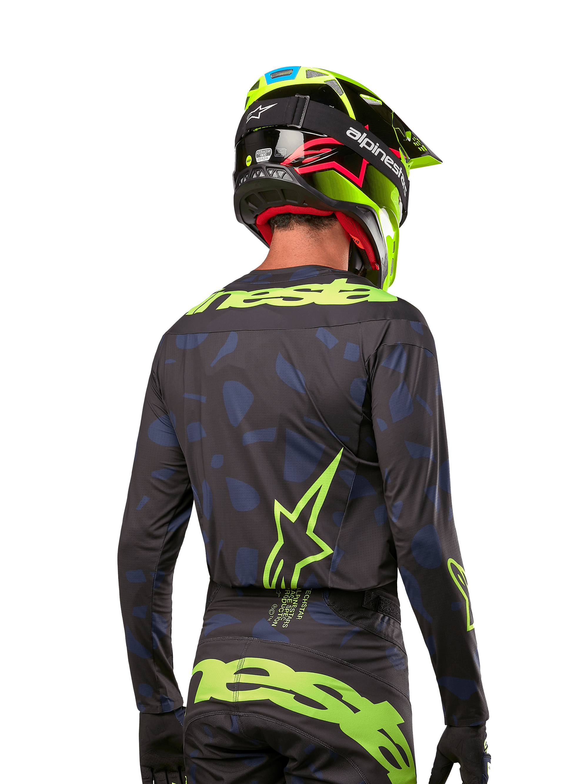 Set bagfra af en motocross-rytter iført Alpinestars 2024 Techstar Rantera Jersey i Black Navy Yellow Fluo, med fremtrædende gul fluo-branding og logoer på ryggen, kombineret med matchende motocross-bukser og en neongul hjelm for et komplet off-road racing-look.