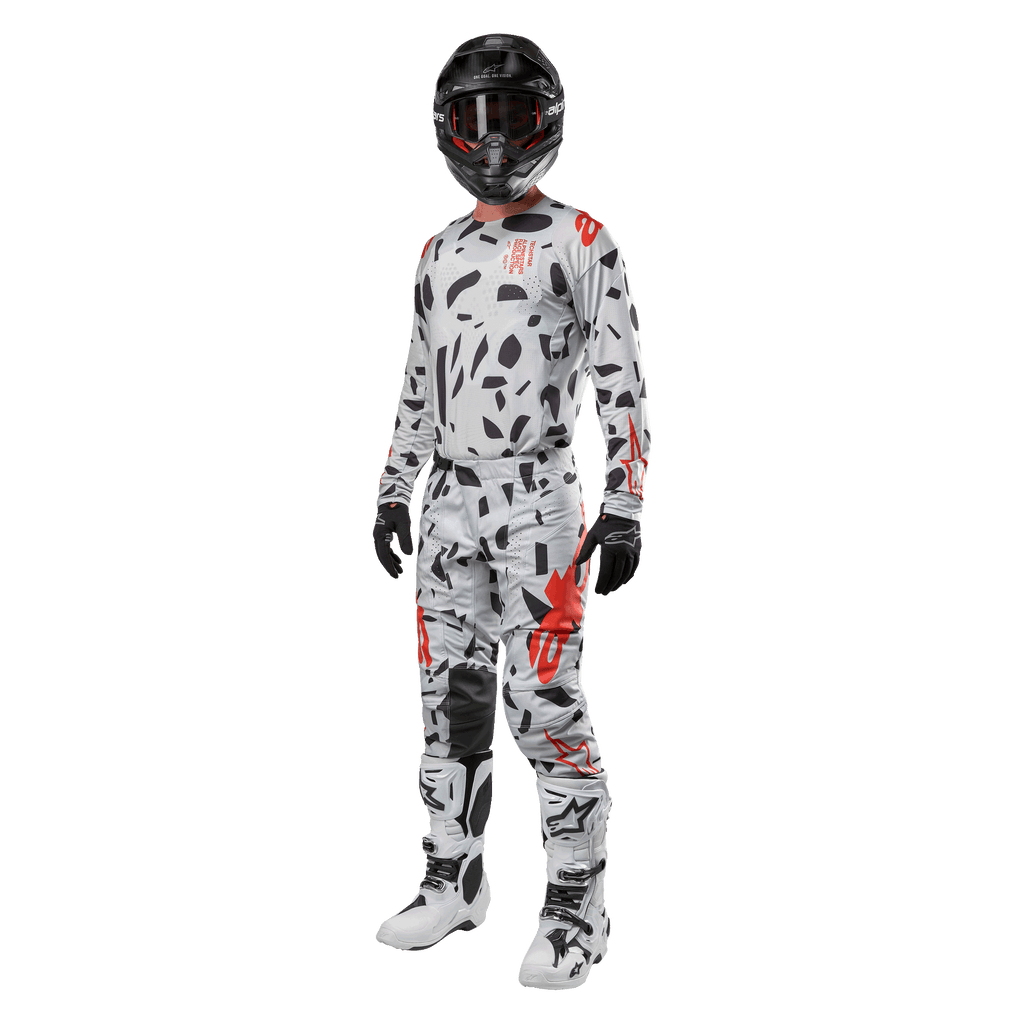 Motocrossrytter iført Alpinestars 2024 Techstar Rantera-trøje i Haze Gray Camo, matchende bukser med røde og sorte detaljer, sort hjelm og goggles, sorte handsker, hvide og sorte støvler, komplet koordineret motocross-racerudstyr til terrænkørsel