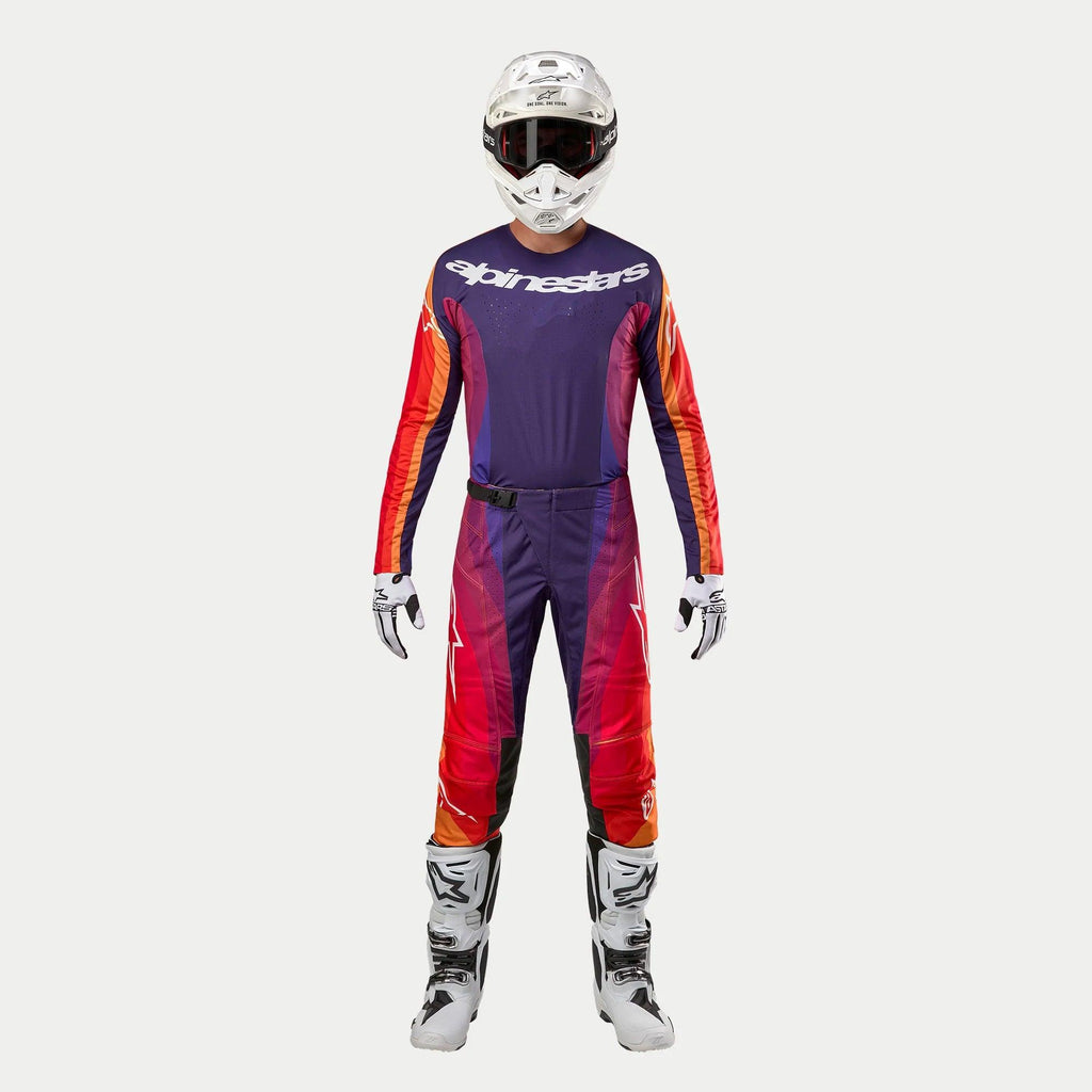 Alpinestars 2024 Techstar Pneuma Gear Set, komplet motocross-udstyr, dyb lilla jersey med orange og røde detaljer, lilla og orange bukser, hvid hjelm, hvide handsker og hvide støvler, professionelt beskyttelsesudstyr til off-road racing