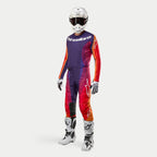 Alpinestars 2024 Techstar Pneuma Gear Set, komplet motocross-udstyr, mørk lilla, orange og mørkeblå, inkluderer jersey, bukser, hvid hjelm, handsker og hvide støvler, professionelt terrænkørselsudstyr.