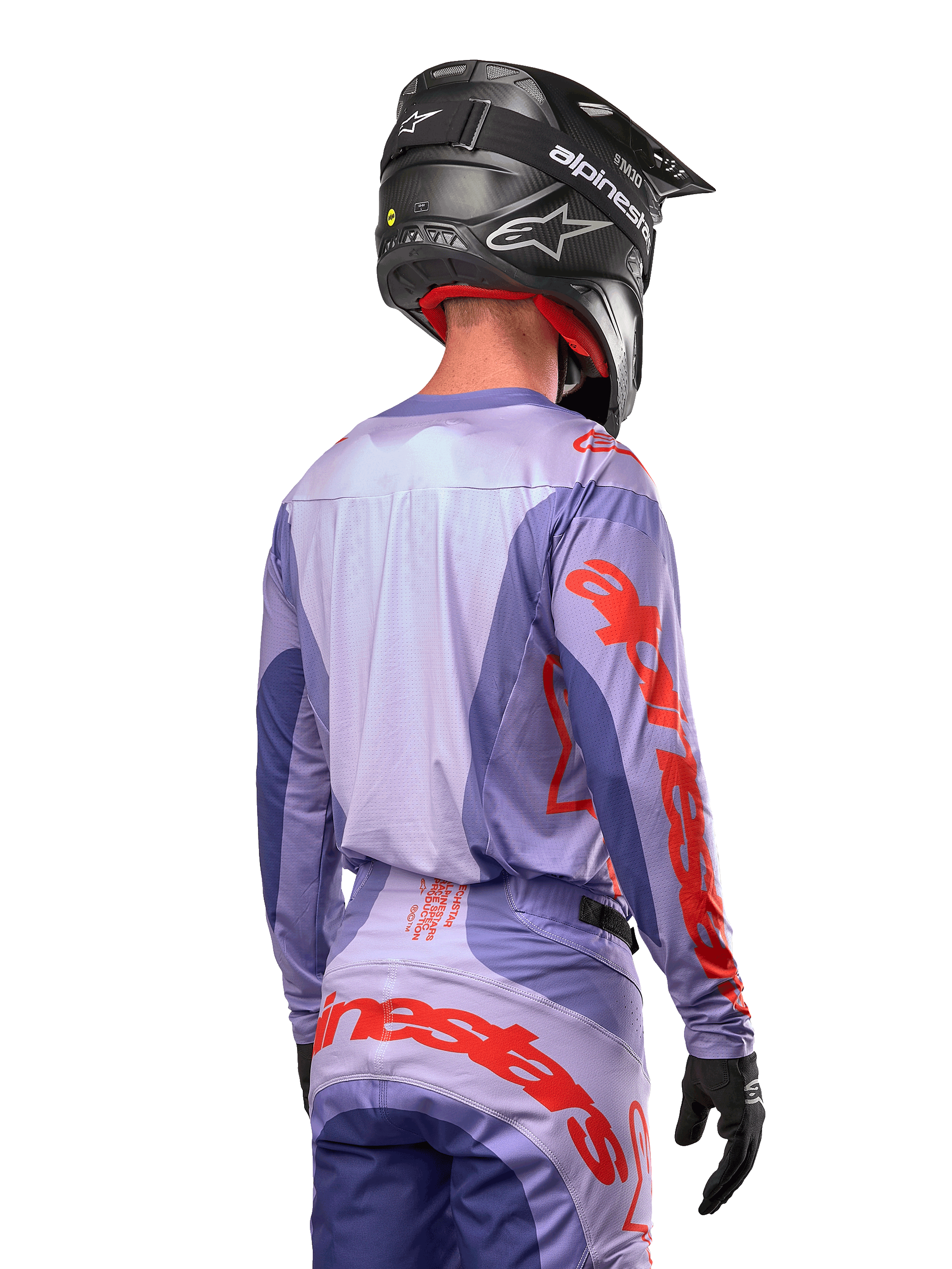 Alpinestars 2024 Techstar Ocuri Jersey, motocross-trøje, lilla og stærk orange, set bagfra på en kører iført matchende udstyr og sort hjelm, med store orange Alpinestars-bogstaver på ærmerne og den nederste del af ryggen