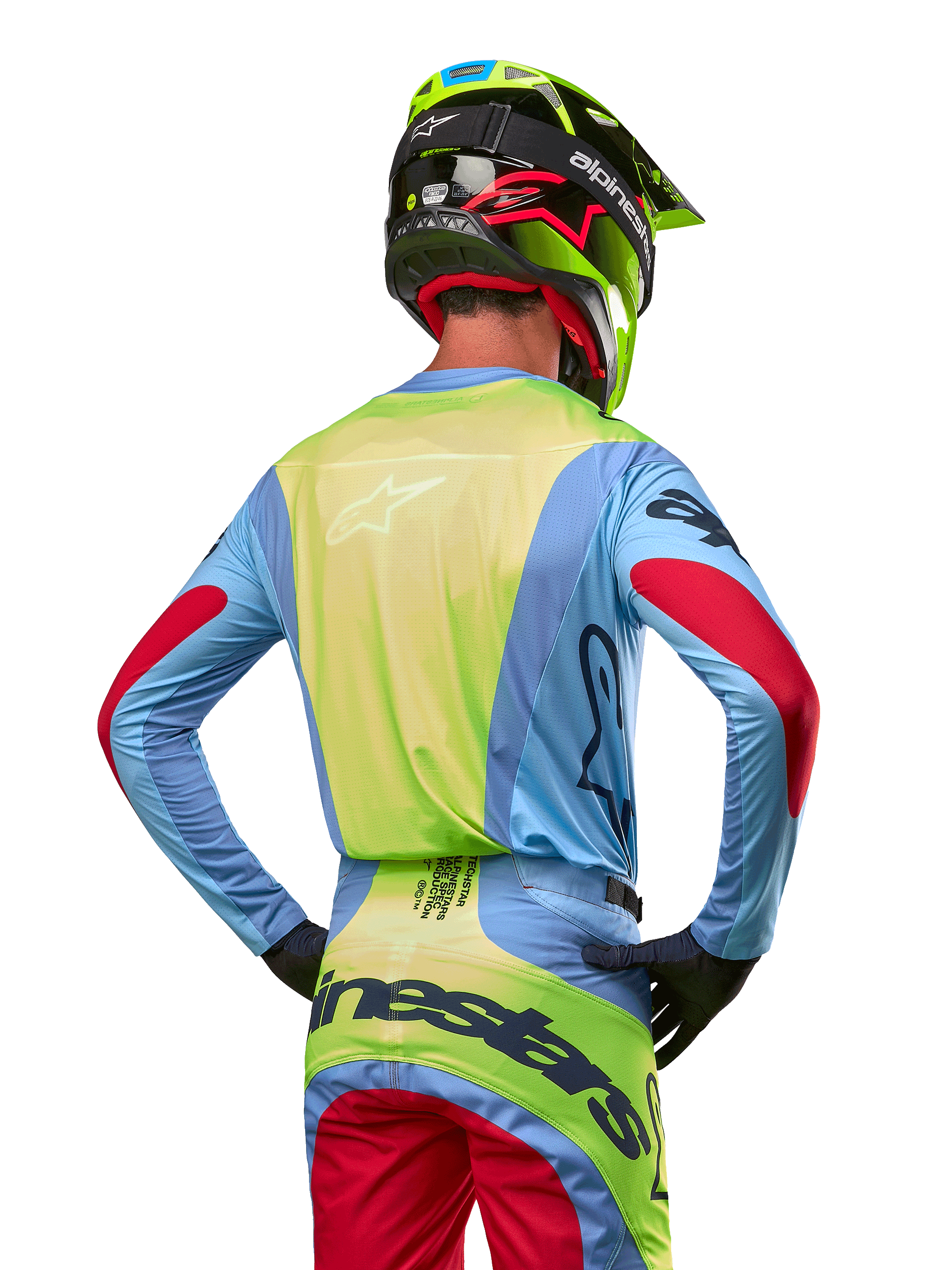 Motocross rider from behind wearing the Alpinestars 2024 Techstar Ocuri Jersey, Light Blue with Fluo Yellow back and Red sleeve accents, matching motocross pants and neon yellow helmet, coordinated outfit for off-road racing
