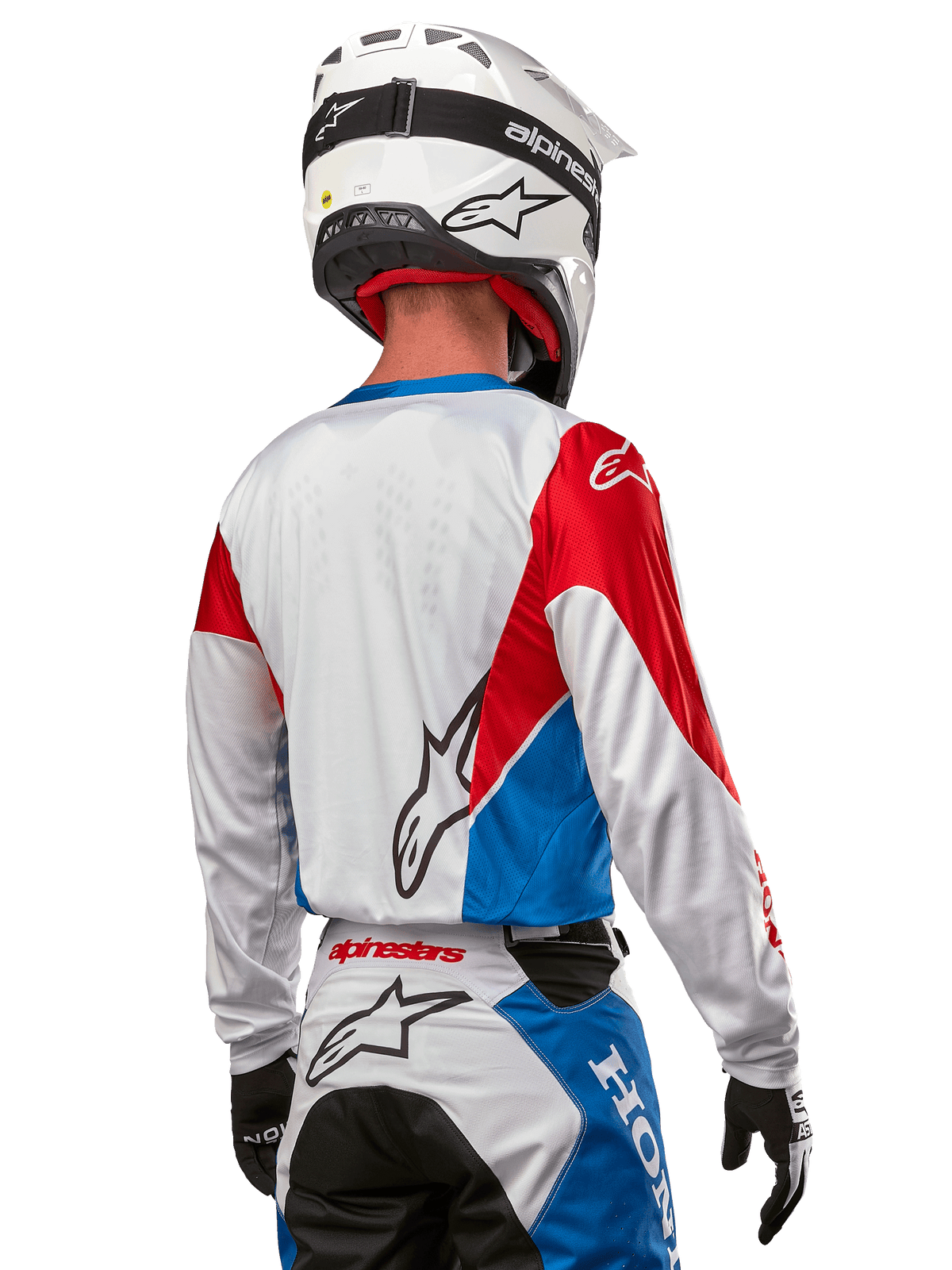 Alpinestars Honda Racer Iconic Jersey, motocross-trøje set bagfra, hvid med klare blå og røde paneler, tydeligt Alpinestars-logo på ryggen, hvid motocrosshjelm og matchende racerbukser, off-road racingudstyr
