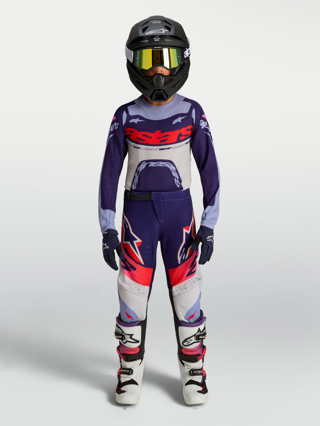Alpinestars 2027 ungdom Supertech Dyna trøje og gear set, lilla og hvidt motocrosstøj til racing med hjelm og støvler.