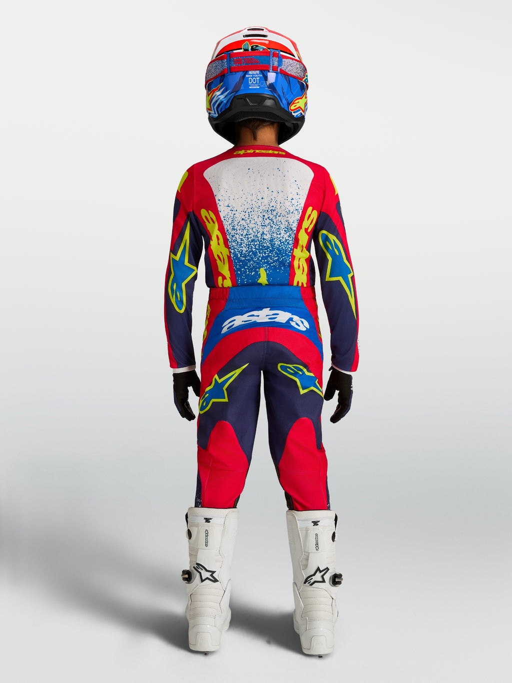 Alpinestars 2027 Fluid Drag trøje og udstyrssæt til ungdom, motocross-sæt, mørkeblå og rød, set bagfra på en rytter.