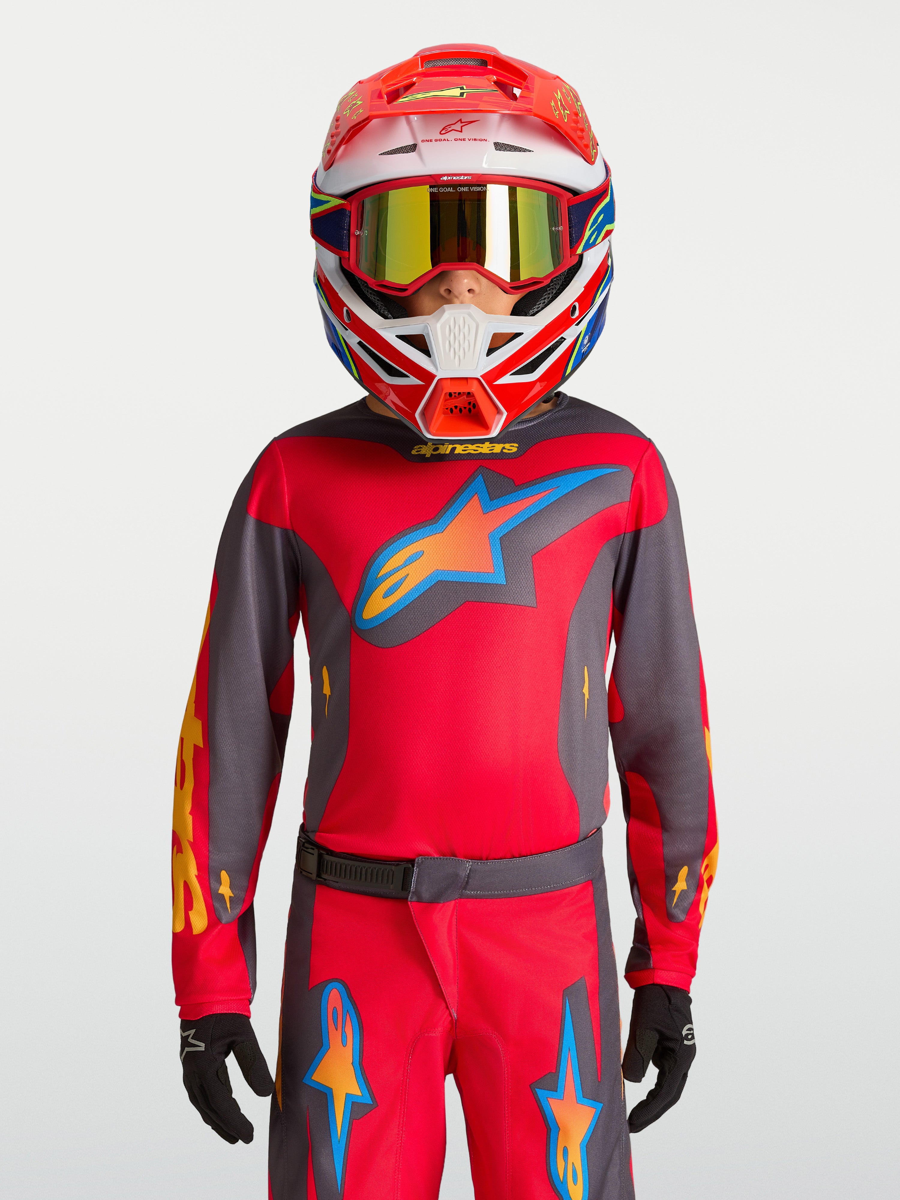 Alpinestars 2027 Fluid Hunt trøje ungdom, rød og grå motocrosstrøje, båret med racerhjelm, teknisk off-road gear