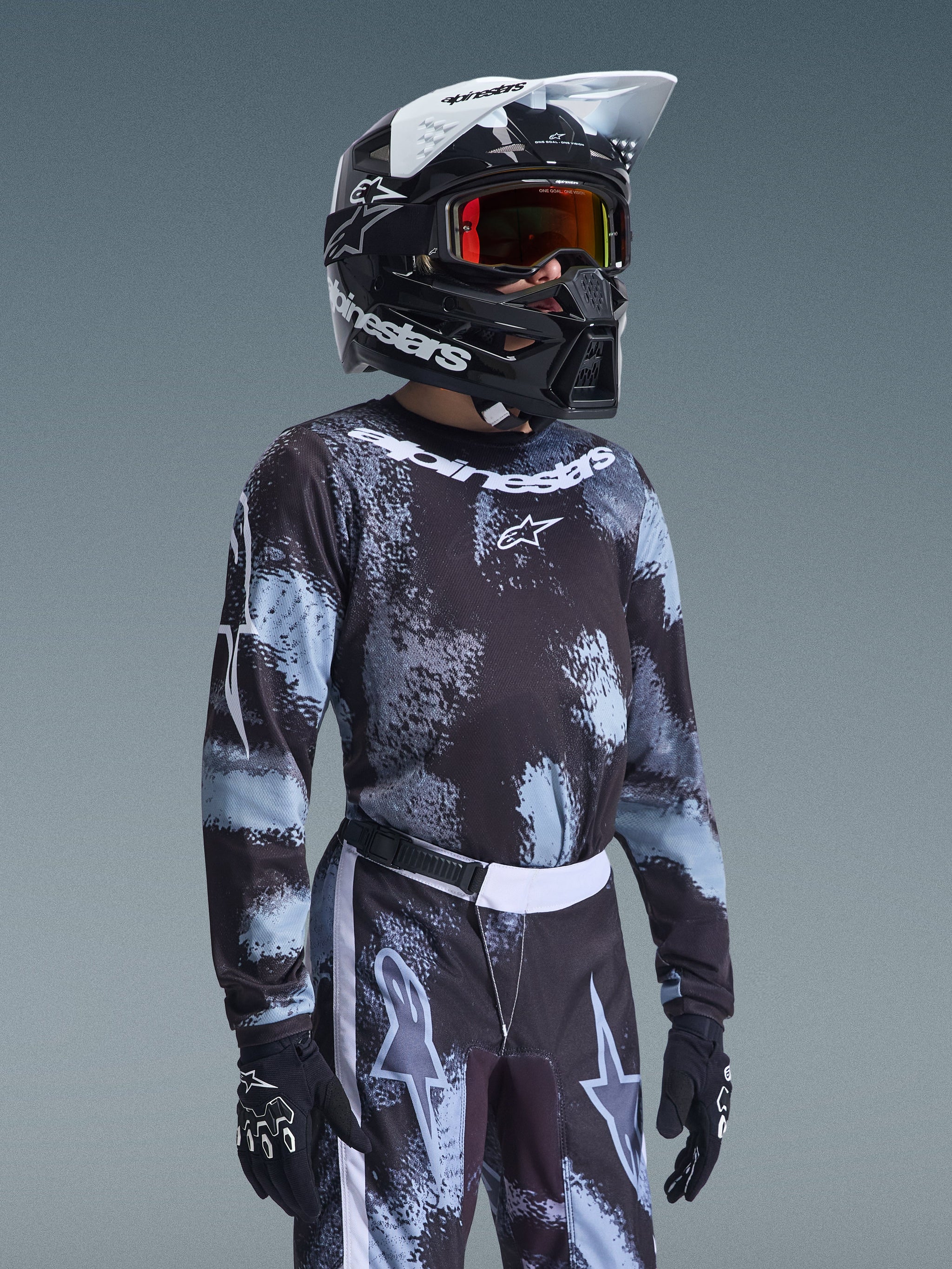 Alpinestars 2026 Youth Fluid Lahnd Jersey, Motocross Jersey, Iron Camo pattern in black and light blue, worn by a youth rider with matching pants and black helmet, coordinated off-road racing gear.