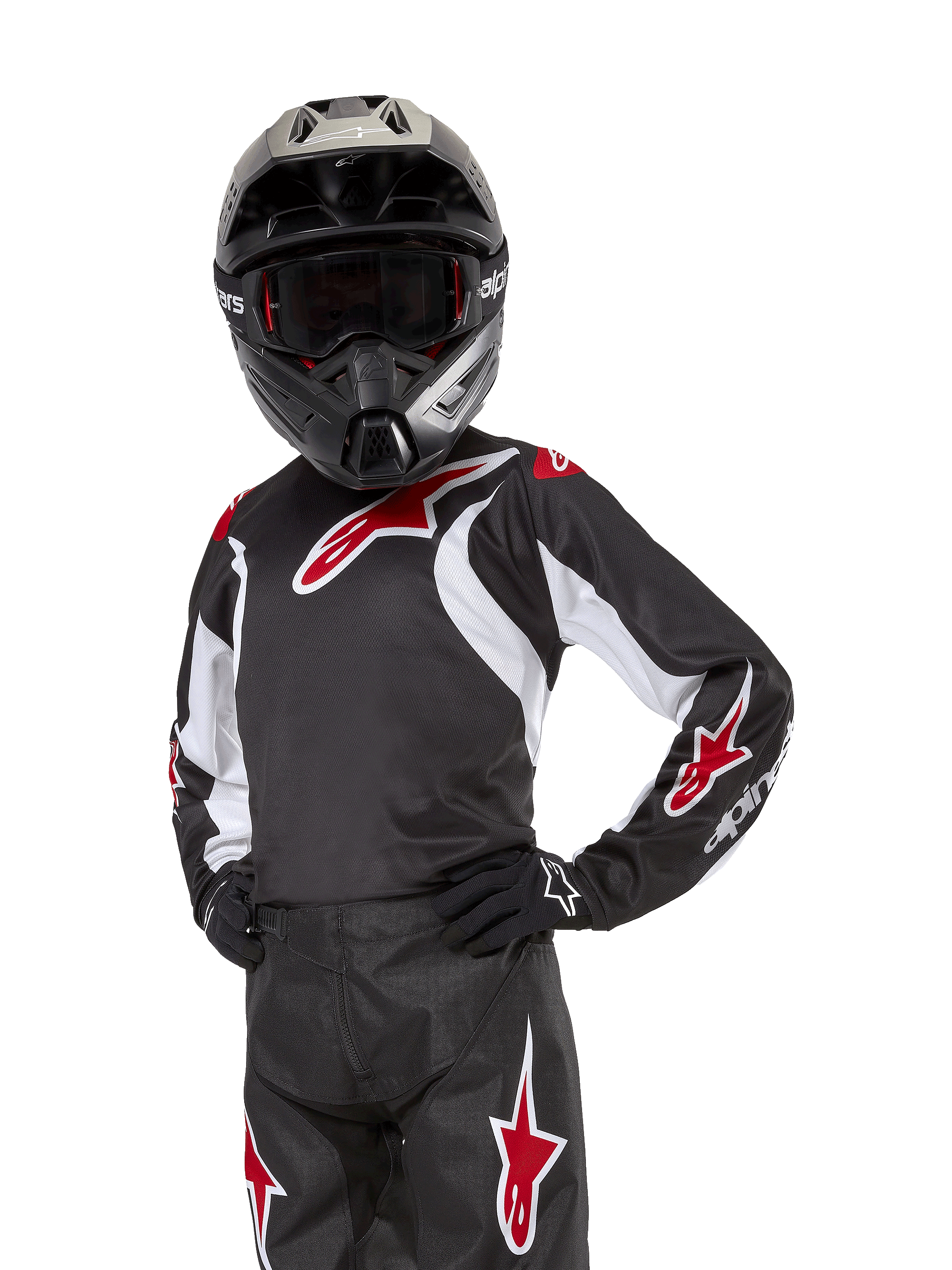 Alpinestars Youth 2024 Racer Lucent Jersey, motocross-trøje, sort, hvid og rød, båret af en ung rytter med en sort hjelm og matchende bukser, med røde stjernelogoer og hvide grafiske detaljer, højtydende off-road-beklædning til motocross-løb