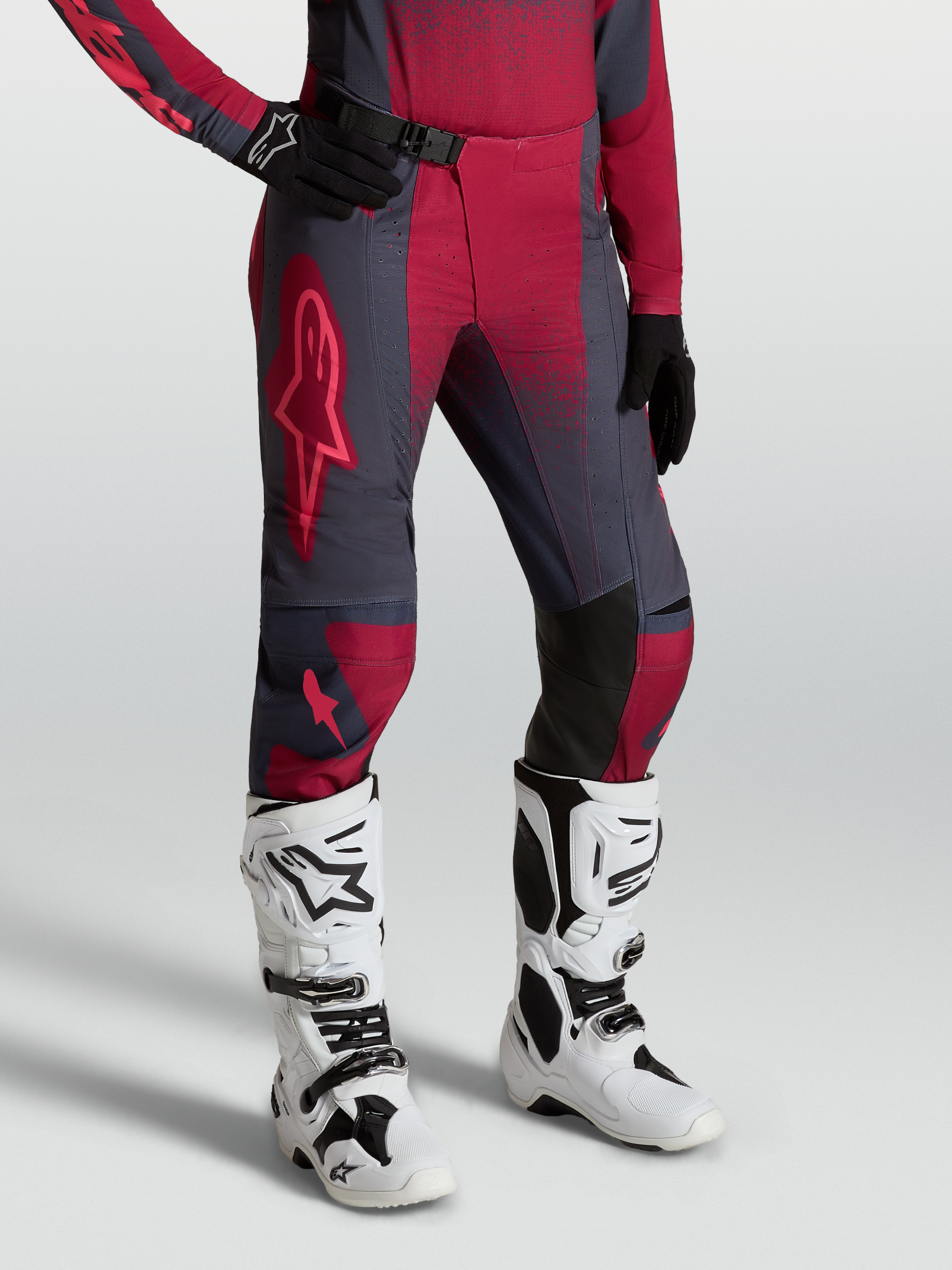 Alpinestars Stella Techstar Swan bukser, dame-motocrossudstyr i rød og mørkegrå, vist med hvide Tech 10 støvler.