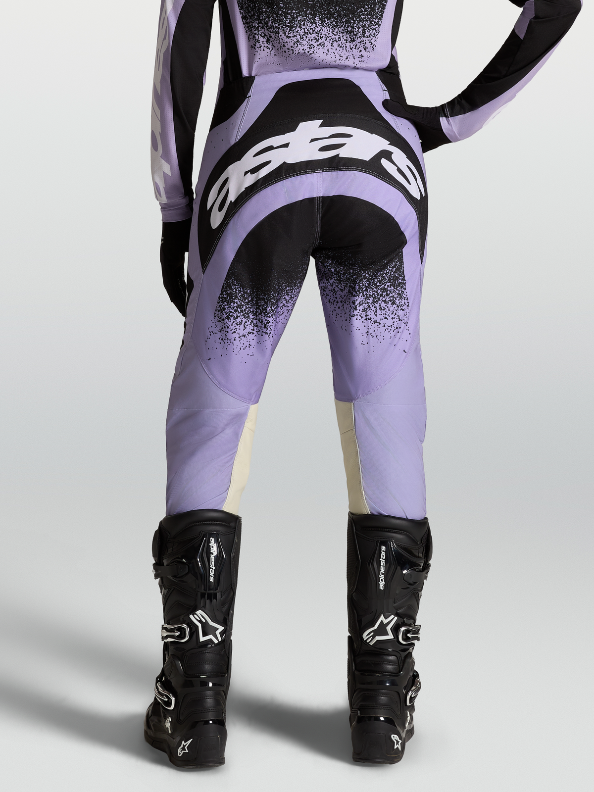 Alpinestars Stella Techstar Swan Pants, women's motocross gear in purple and black with white logos, worn on-model with black boots.