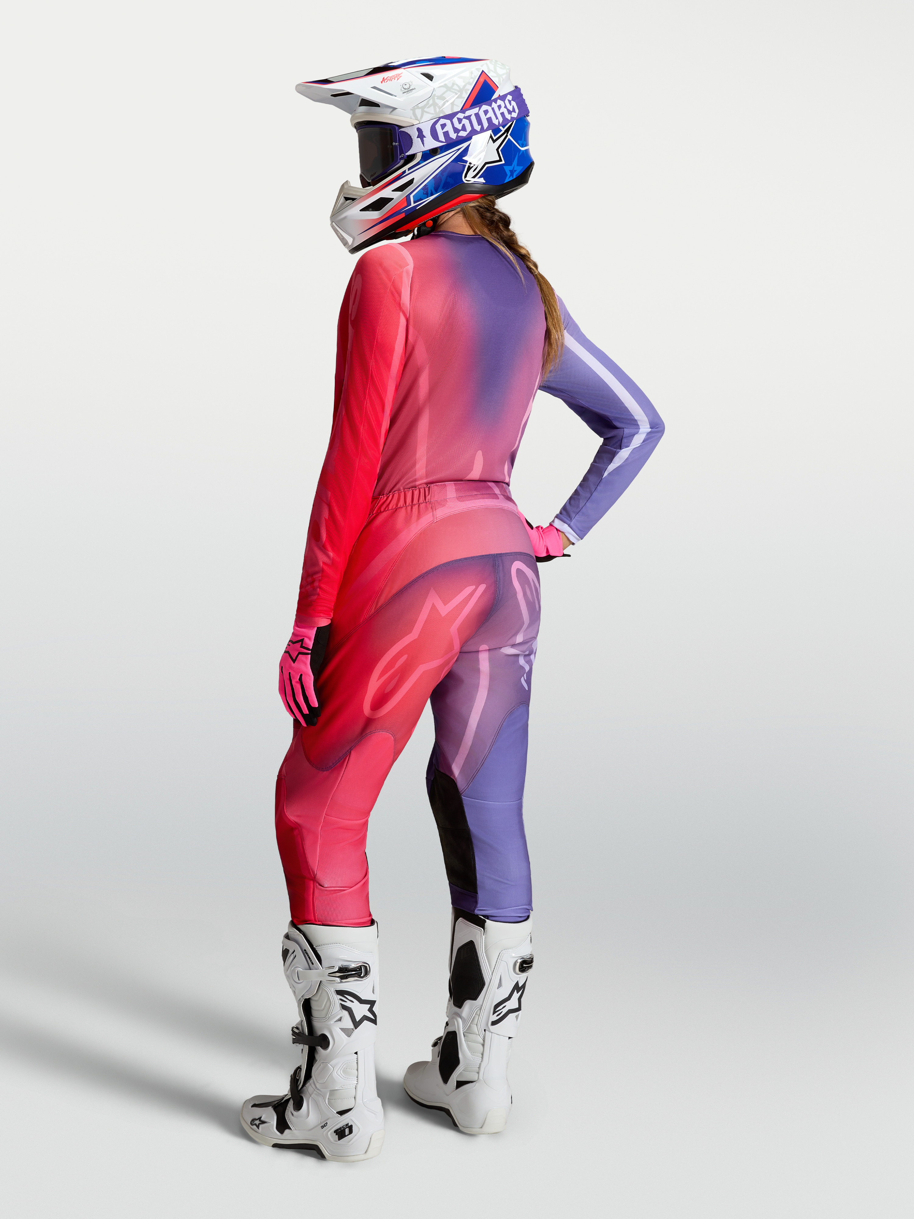Alpinestars Stella Fluid Kepler Trøje, motocross-trøje til damer, lilla og rød, vist bagfra med matchende bukser og hvide støvler.