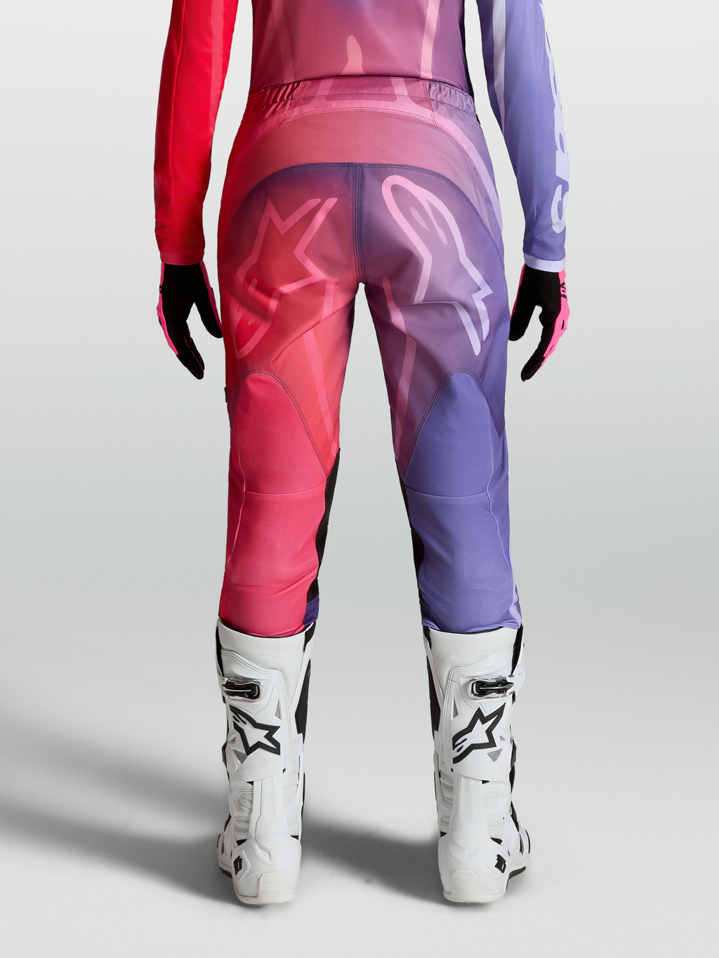 Alpinestars Stella Fluid Kepler Bukser, dame-motocrossbukser i lilla og rød, set bagfra med hvide støvler, præformet ergonomisk pasform.