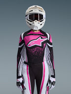 Alpinestars 2026 Stella Techstar Nomur udstyrssæt, motocross-outfit til kvinder, lyserød, sort og hvid med stort stjernelogo, bestående af matchende jersey, bukser og handsker med en hvid hjelm, set forfra på en grå baggrund