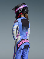 Alpinestars 2026 Stella Techstar Nomur Gear Set, motocross udstyrssæt til kvinder set bagfra, lyseblå med lyserøde og sorte detaljer, matchende jersey og bukser, sort hjelm med lyserøde goggles, ergonomisk pasform til off-road racing