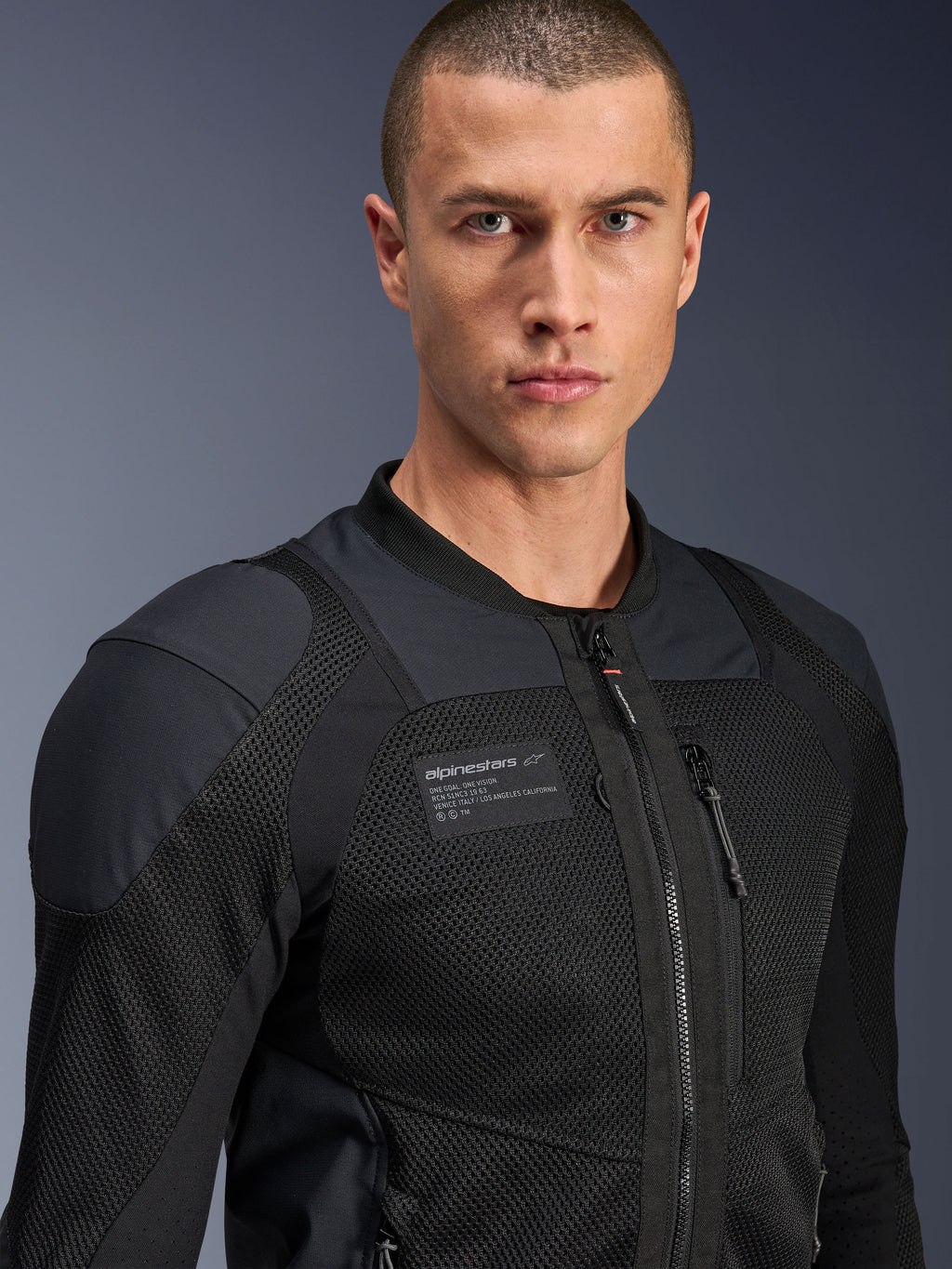 Alpinestars Troop-Air Pro jakke, sort, teknisk pansret luftjakke til motorcykelkørsel, nærbillede-portræt, der viser 2D-mesh-tekstur og branding-mærke på brystet.
