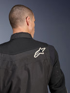 Alpinestars T-Dyno Air Jakke, sort tekstil motorcykeljakke, nærbillede bagfra der fremhæver det åndbare 3D-mesh-bærestykke og ærmerne, hvidt og sort stjernelogo på højre skulder