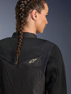 Alpinestars Stella T-Dyno Air Jakke, sort motorcykeljakke til kvinder, nærbillede bagfra der viser 3D-mesh-paneler på bærestykket og den øvre ryg for luftstrøm, med et lille hvidt stjernelogo, båret af en model med flettet hår.