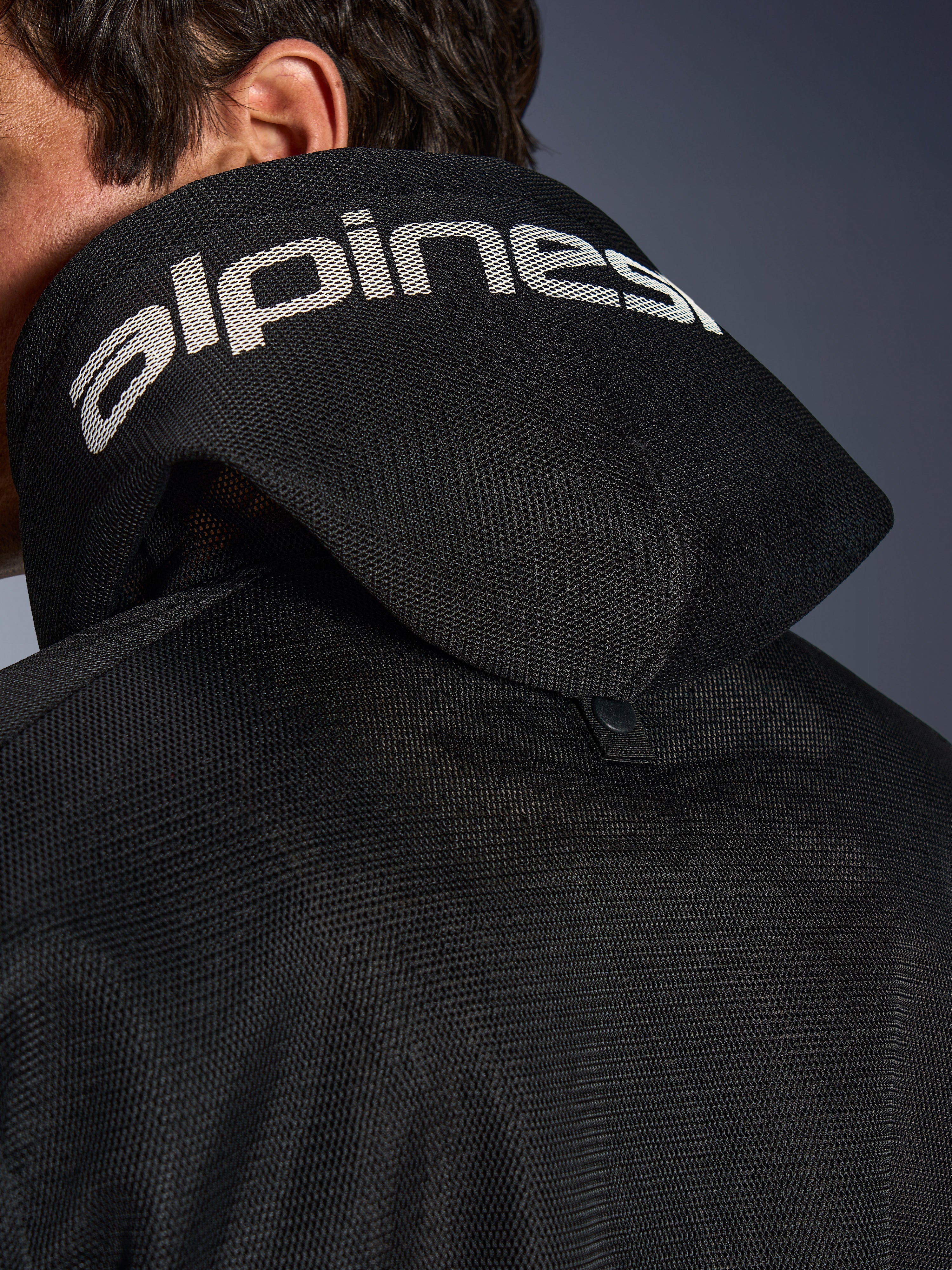 Alpinestars Chrome Superairflow Hoodie, sort, detaljeret visning af 3D mesh-hætten med hvid Alpinestars-branding over toppen, der viser den bageste stabiliseringstrykknap, ventileret tekstil-motorcykeludstyr til ekstrem varme