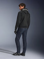 Alpinestars Chrome Superairflow Hoodie, sort, set bagfra på mandlig model, med hvidt Alpinestars-logo på hætten, båret med mørke denimjeans og sorte handsker, urbant motorcykeludstyr
