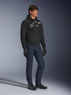 Alpinestars Chrome Superairflow Hoodie, sort med hvidt og gråt logo, ventileret 3D mesh-tekstilkonstruktion, båret med mørkeblå denimjeans og sorte motorcykelhandsker, urban sport-kørestil.