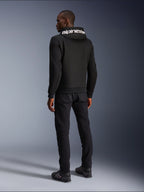 Alpinestars Chrome V2 Sport Hoodie, sort, set bagfra med hvidt Alpinestars-branding på hætten, båret med sorte bukser og køresko, afslappet urban motorcykelbeklædning med en atletisk silhuet