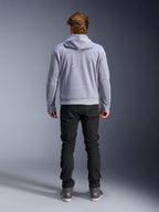 Alpinestars Chrome V2 Sport Hoodie, Gray Heather Fluo Yellow, set bagfra af urbant motorcykeludstyr, tech fleece-hættetrøje båret med sorte bukser, med fluorgule detaljer på ærmerne.