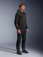 Alpinestars Chrome Air Sport Hoodie, Black Red Fluo, urban motorcykeljakke med tech-fleece, båret med sorte bukser og motorcykelstøvler, med mesh-ventilationspaneler og røde fluorescerende logoer på brystet og ærmet.