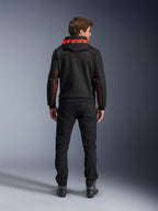 Alpinestars Chrome Air Sport Hoodie, Black and Red Fluo, set bagfra af mand iført afslappet motorcykeljakke, med rød Alpinestars-branding på hætten og røde mesh-paneler på ærmerne, kombineret med sorte bukser