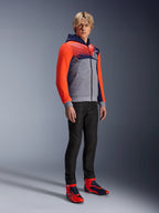 Alpinestars MM93 Chrome V2 Sport Hoodie, urban motorcykel-hættetrøje, gråmeleret krop med navyblåt bryst og neonrøde ærmer, med 93-logoet på brystet, båret af en model med sorte slim-fit bukser og matchende røde og blå high-top køresko, moderne atletisk pasform til bykørsel