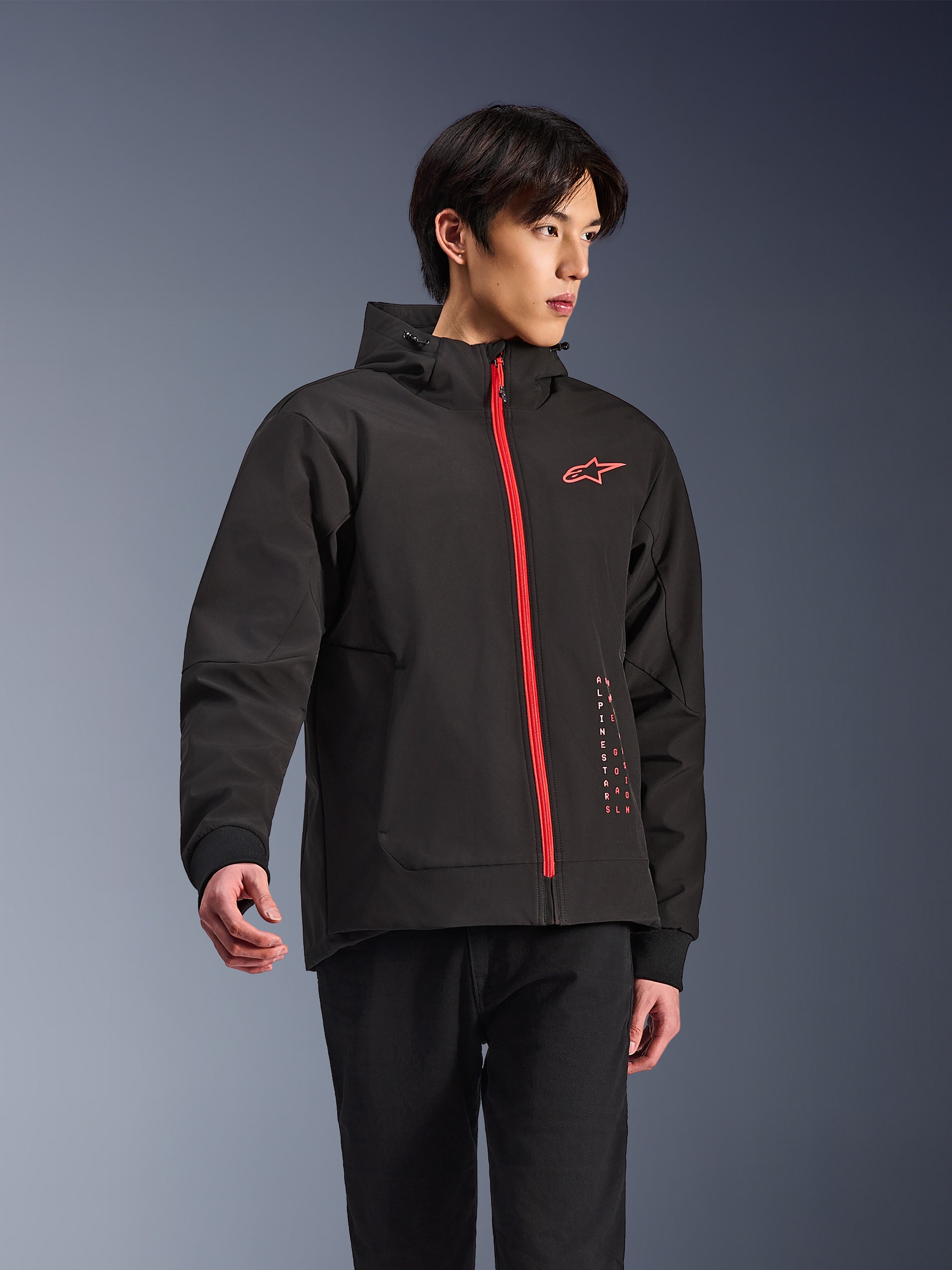 Alpinestars Radium Tech Hoodie, urban motorcykeljakke, sort med klar rød lynlås, med rødt Alpinestars-logo på brystet og rød tekst på siden, teknisk vindtæt skal med hætte og ribbede manchetter, moderne street-stil til motorcyklister