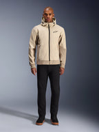 Alpinestars Radium Tech Hoodie i Mastic Aluminum, urban motorcykelhættetrøje båret af en mandlig model med sorte bukser og sorte støvler, med gennemgående sort lynlås, lille logo på brystet og atletisk pasform til bykørsel