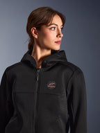 Kvinde iført Alpinestars Stella Chrome Superairflow hættetrøje, sort med kobberfarvet logo, 3D-mesh-konstruktion for maksimal luftgennemstrømning, teknisk motorcykeludstyr designet til kvinder, urban sport-kørestil