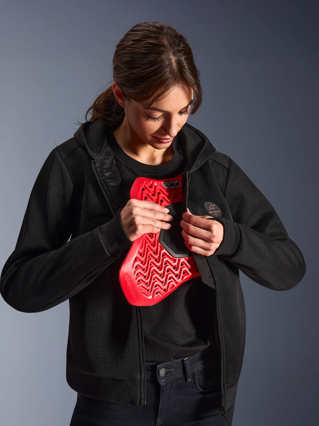 Alpinestars Stella Chrome Superairflow Hoodie, motorcykel-hættetrøje til damer, sort, model der holder en rød Nucleon brystbeskytter, letvægts 3D-mesh-konstruktion til by- og sportskørsel