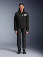 Kvinde iført Alpinestars Stella Chrome V2 Sport hættetrøje, sort med hvidt Astars-logo på brystet, kombineret med sorte tekniske motorcykelbukser og støvler, urbant motorcykeltøjsdesign