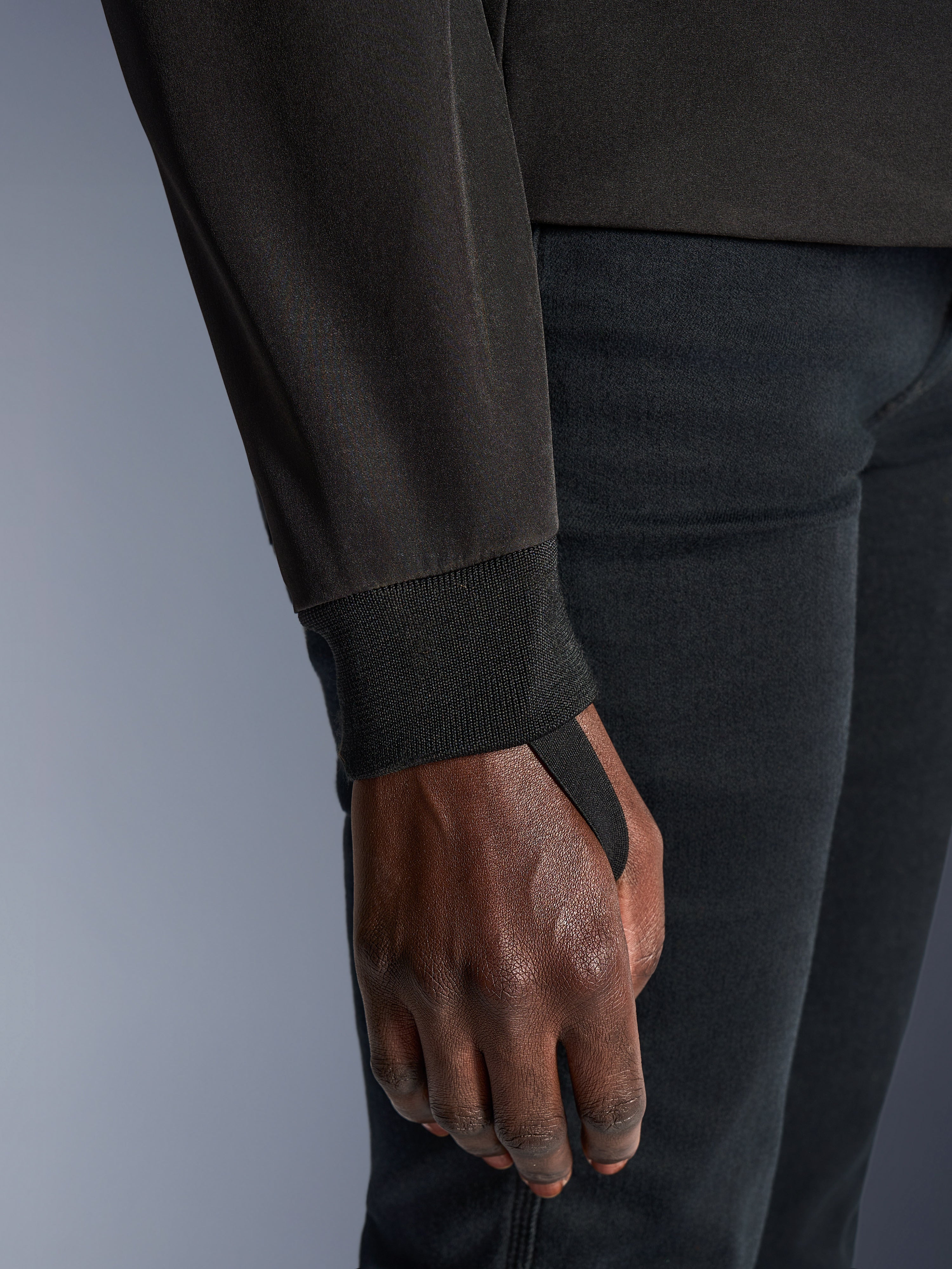 Close-up of Alpinestars Woman Stella Radium Tech Hoodie in Deep Gray Black, highlighting the ribbed stretch cuff and thumb loop for wind sealing and secure fit during urban riding.