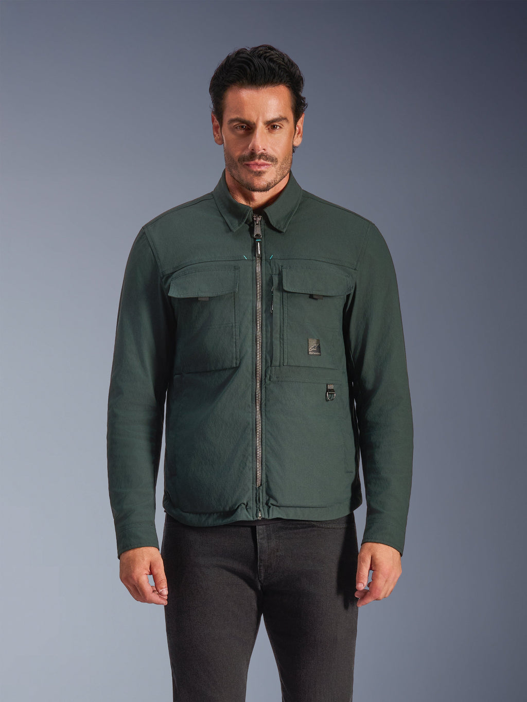 Alpinestars Bryon Water Resistant Overshirt, Dark Emerald, urban motorcykeljakke til mænd, mandlig model iført mørkegrøn overshirt med lynlås foran og store brystlommer, vandafvisende vokset lærred til motorcykelkørsel