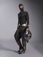 Alpinestars ZX Evo V3 Balaclava, Black, worn by a driver with complete auto racing base layer gear, featuring the white logo on the forehead, holding a carbon fiber helmet with an iridescent visor, professional fire-resistant motorsport apparel.