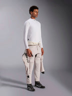 Alpinestars ZX Evo V3 Langærmet Top, hvid flammebestandig base layer til bilvæddeløb, bæres af en model med en køredragt bundet om taljen, letvægts tech-lag med høj hals og logodetalje.
